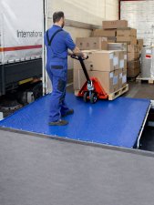 Palldragare lackad kör på fällbar lastbrygga för lastkaj