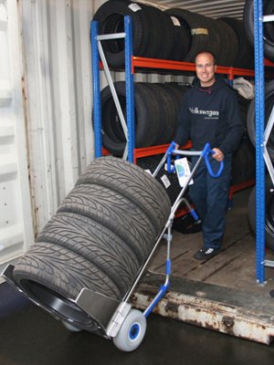 Däckkärra kör ut ut container full med däck