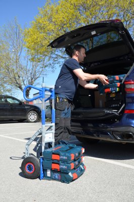 Tekniker lastar in verktygslådor från sin fällbara aluminiumkärra