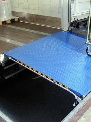 Fällbar lackad lastbrygga mellan lastkaj och flak