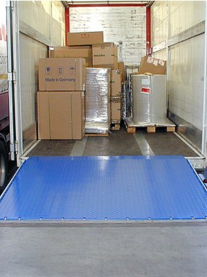 Fällbar lackad lastbrygga mellan lastkaj och flak