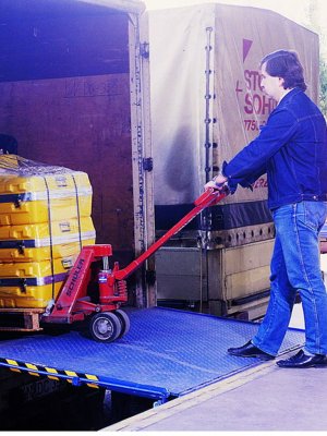 Palldragare kör på fällbar lackad lastbrygga för lastkaj